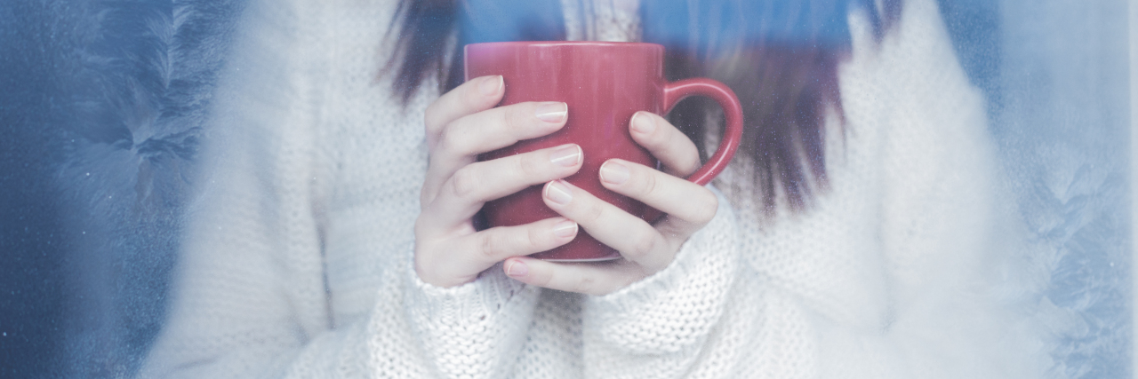 a woman's hands holding a red cup