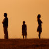 silhouette of a man and woman standing across from each other and a little girl in the middle