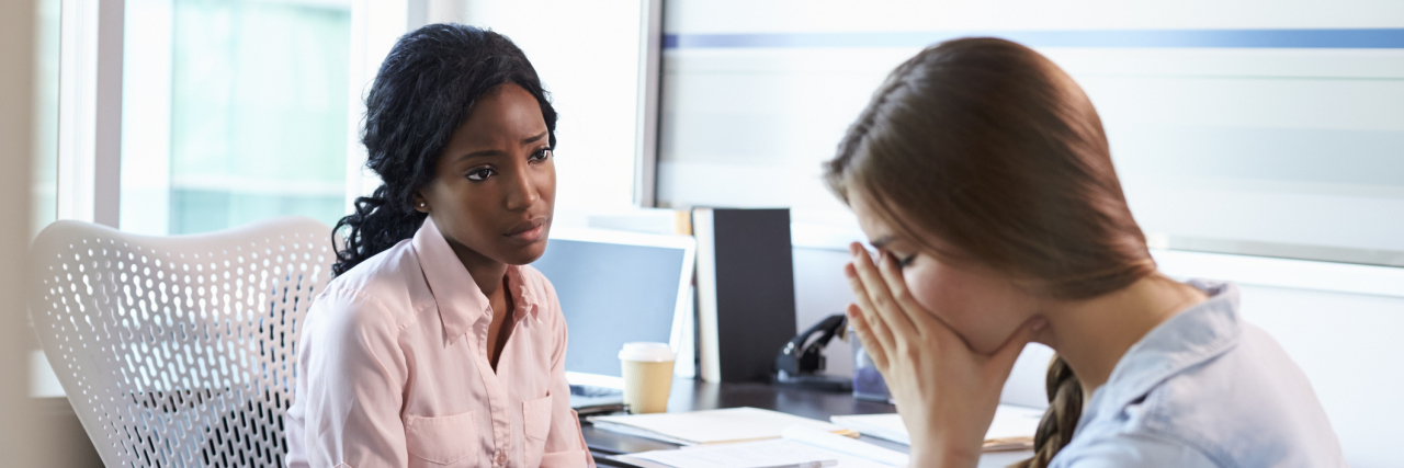 Getting a Second Opinion on My Bipolar Medication Saved My Life A young white woman distressed covering her face sitting across from a Black female doctor, consoling her