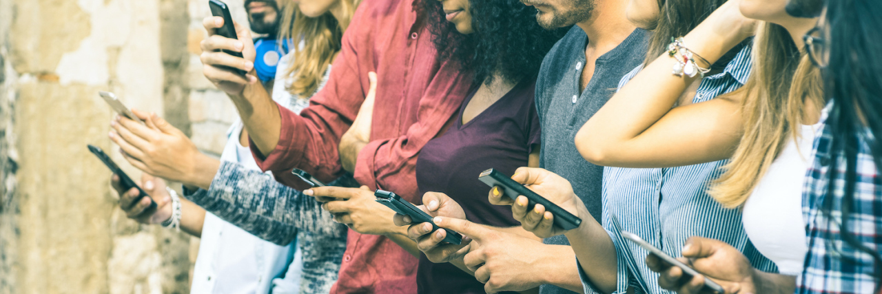 The Importance of Authenticity in Social Media to Your Mental Health Group of multicultural friends using smartphones outside