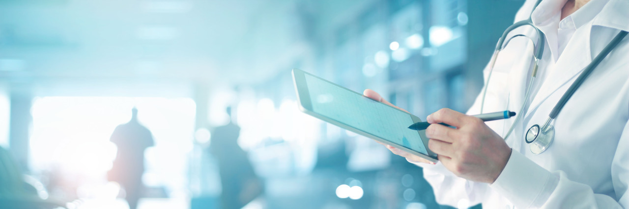 How Health Care Practitioners Can Address Medical Gaslighting Doctor with tablet making notes.