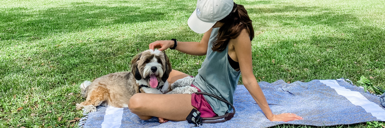 the author sitting outside on a blanket with her dog