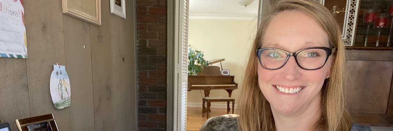 When Your Rare Disease Diagnosis Is Complicated Photo of woman wearing glasses and holding a mug that says "strong vibes calm mind"