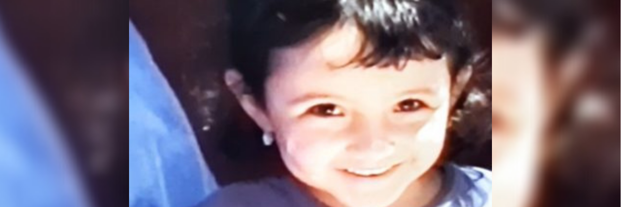 To My Younger Self, Before Any Mental Illness or Disability: Thank You photo of the author as a child; young white girl with short, dark hair in a purple sweater smiling