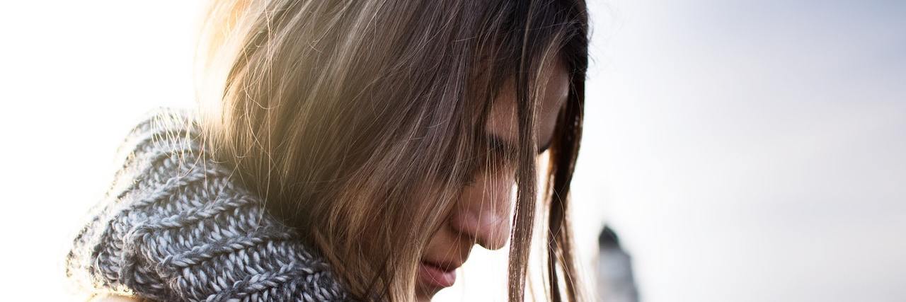 Reflections on Living With Chronic Illness for 5 Years Woman with long hair wearing scarf outside