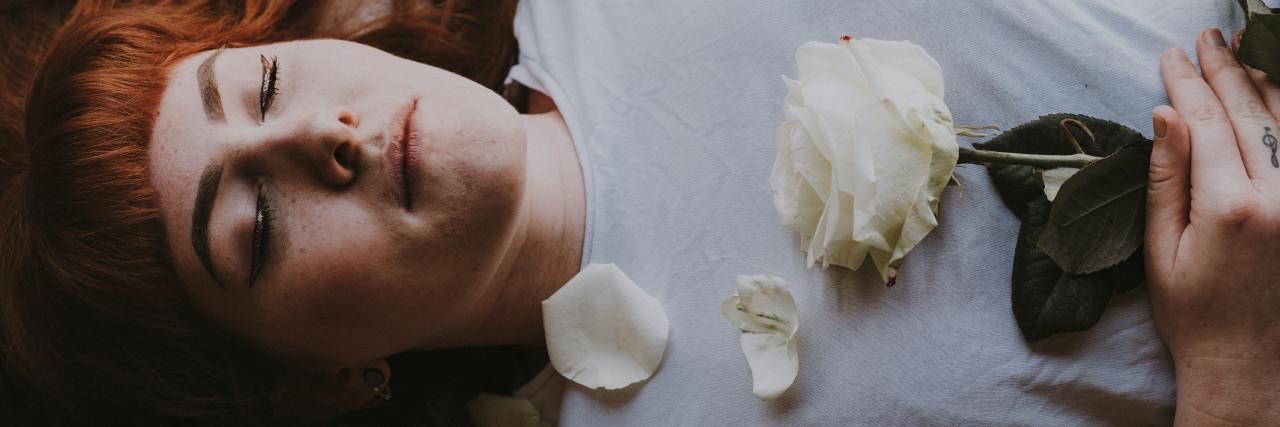 The Positives of Memory Loss From Electroconvulsive Therapy woman sleeping or lying down with her eyes closed, a rose on her chest, photo taken from above