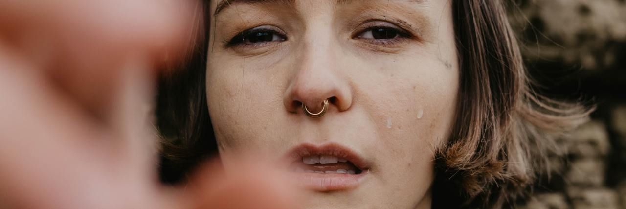 photo of woman looking into camera and crying