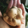 Photo of hands holding a small "buddha weeps" statue