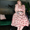 Contributor sitting on rollator wearing a dress with cherries and red shoes