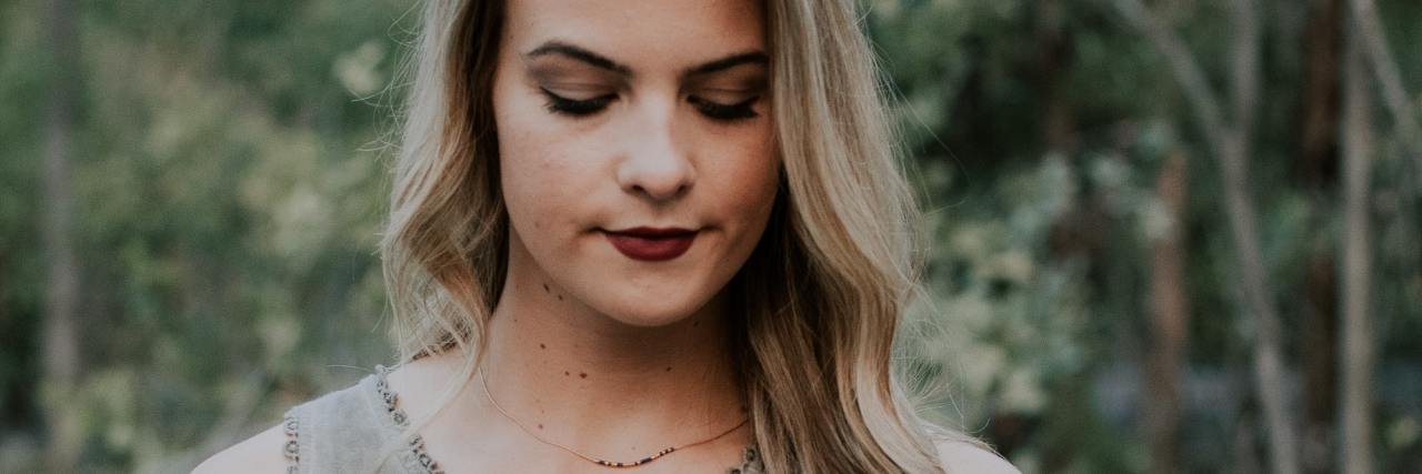 People Who Are Silent About Abuse Have To Be Held Accountable photo of woman holding her hair, her eyes closed and facing down with fierce expression