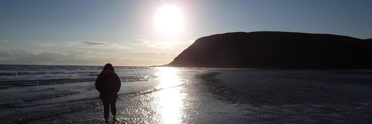 Practicing Self-Care When You Have Chronic Illness Photo of contributor walking on the beach at sunset