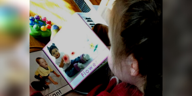 Elena's daughter, who has Down syndrome, reading a book.