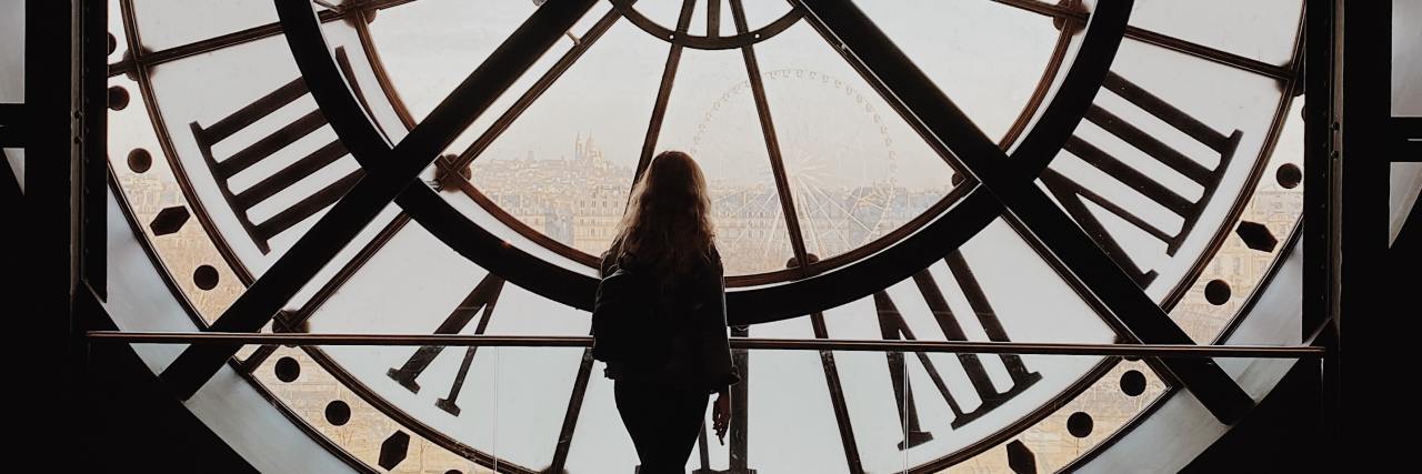 photo of woman silhouetted against a clock inside a clock tower
