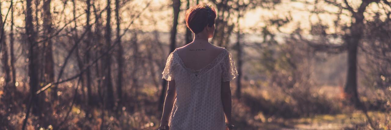 Yes, You Can Leave Eating Disorder Treatment and Not Be Recovered photo of woman walking along road at sunset through trees