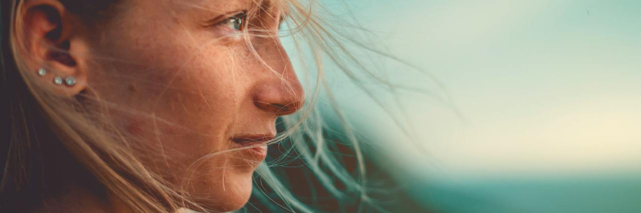 Emotional Pain Caused by My Chronic Illness Is Valid A woman outside, wind sweeping her hair