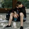 photo of young boy sitting on steps while wearing a coronavirus covid-19 mask