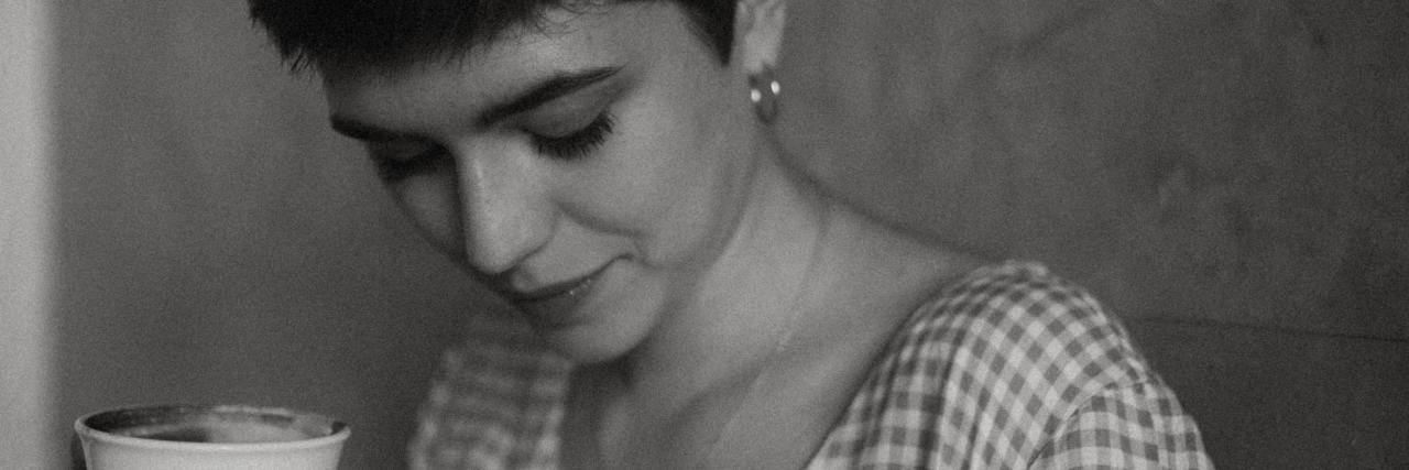 Realizing My Perfectionism Comes From Childhood Trauma black and white photo of woman with short hair holding a cup and looking down