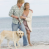Photo of Owen Wilson and Jennifer Anniston with dog on a beach