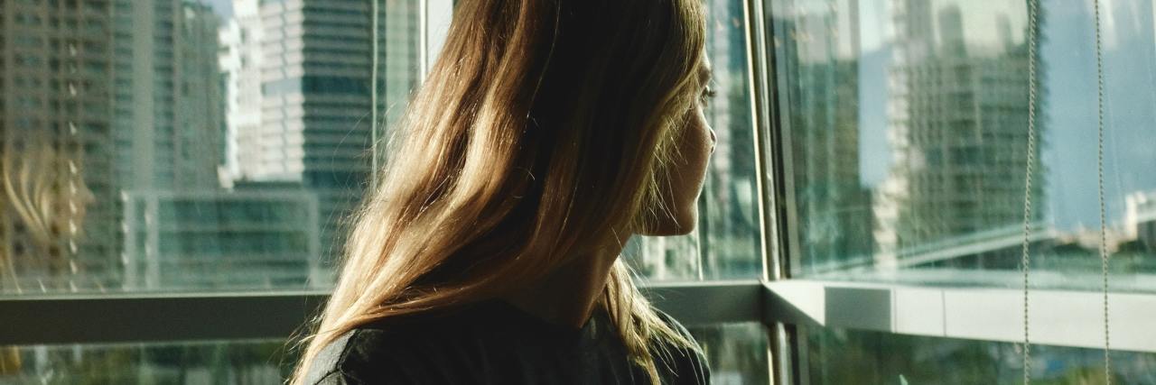 'Microsteps' and Starting Small to Improve Your Mental Health photo of woman looking over shoulder, out of windows at city and freeway behind her