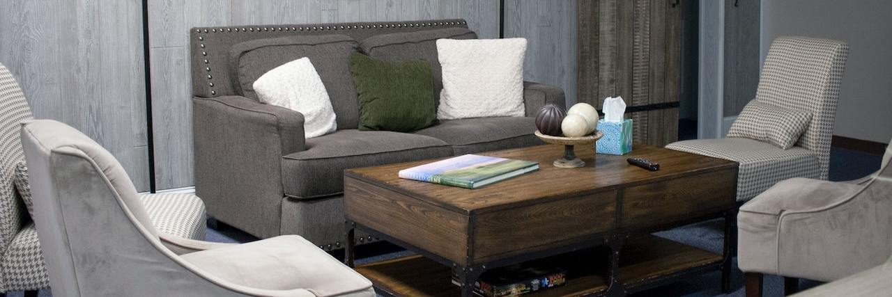 'Peer Respites' Provide Alternative to Psychiatric Wards During COVID Room with a couch, two chairs and a wooden coffee table