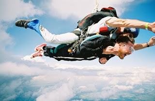 two men in freefall, sky in background