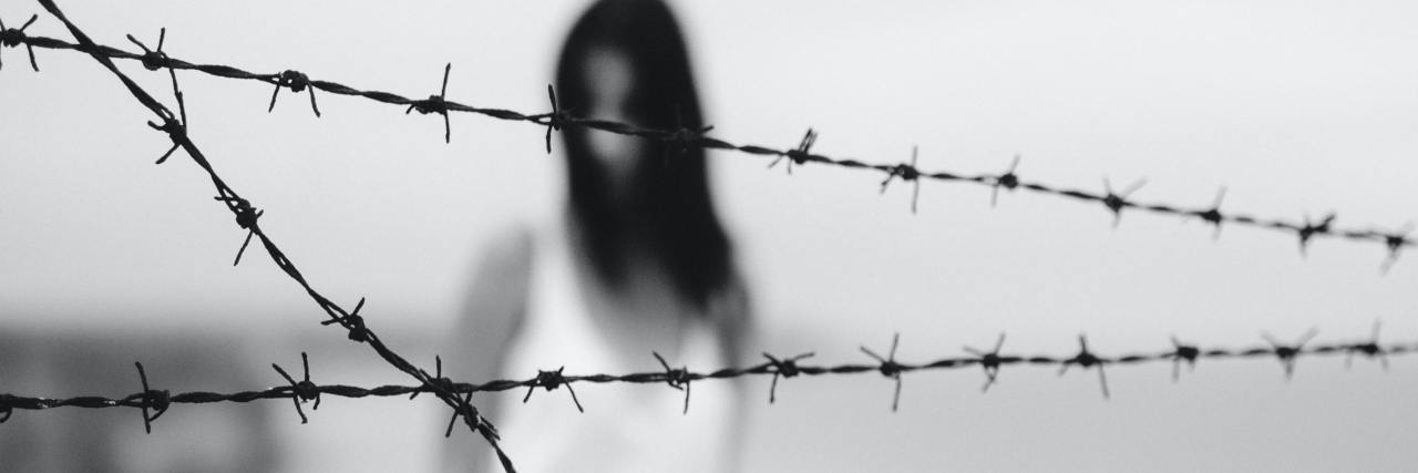 Why the Capitol Attack Triggered My Intergenerational Holocaust Trauma black and white photo of woman blurred behind clear image of barbed wire