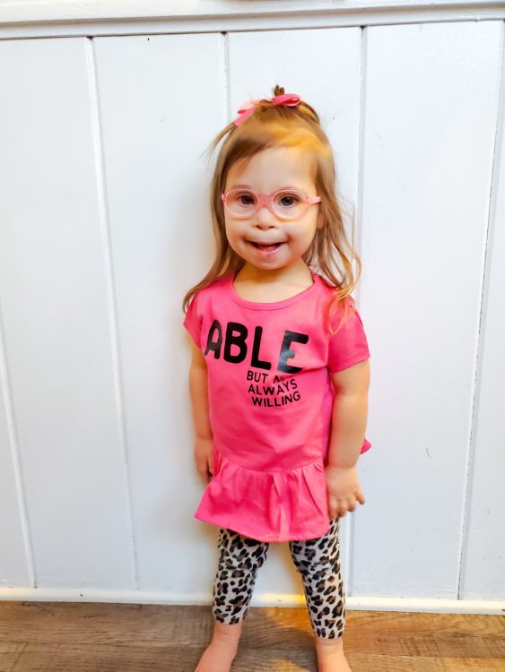 Ivy wearing a pink shirt that says Able.