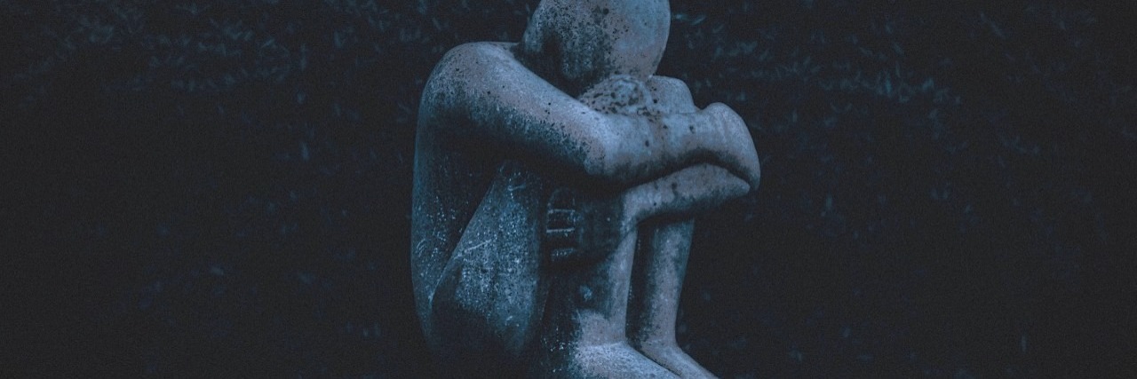 Getting Taken Away From a Parent With Schizophrenia A statue of a person holding themselves while sitting