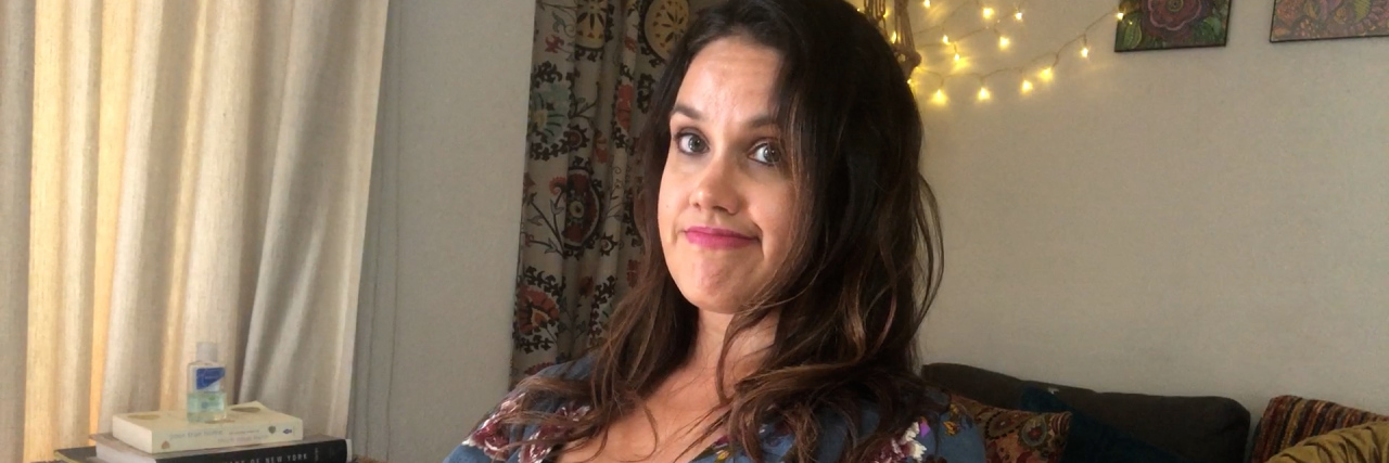 Film 'Full Picture' Experiments With Wheelchair First Impressions Actress Santina Muha, a woman with long brown hair wearing a blue floral print shirt and sitting with her arms folded