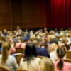 Unfocused, blurry image of young students in auditorium