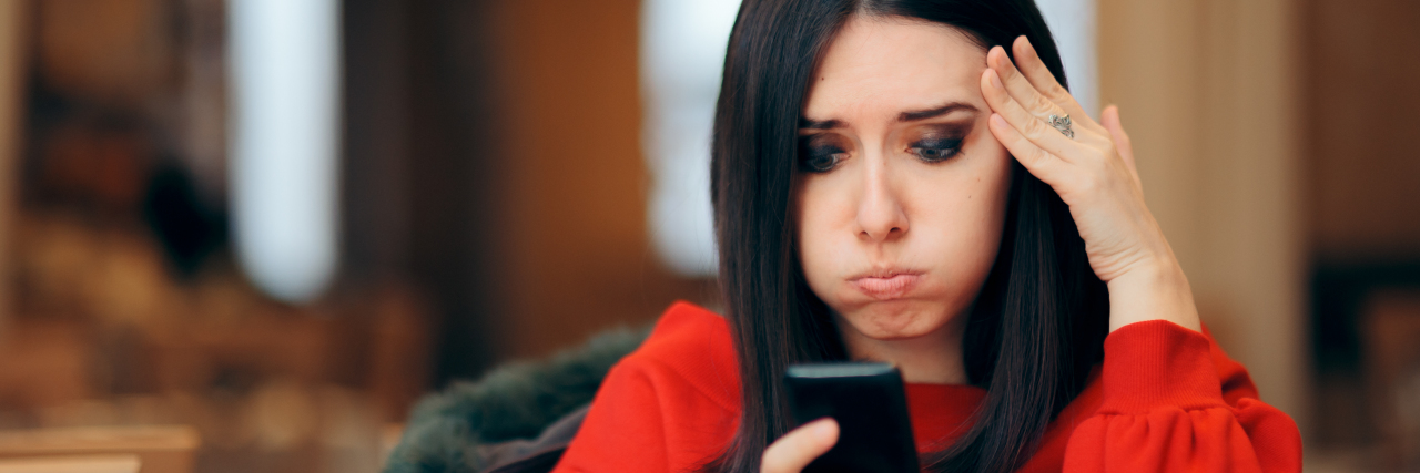 Upset woman looking at cell phone.