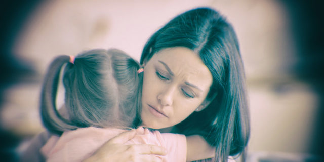 Mother hugging daughter.