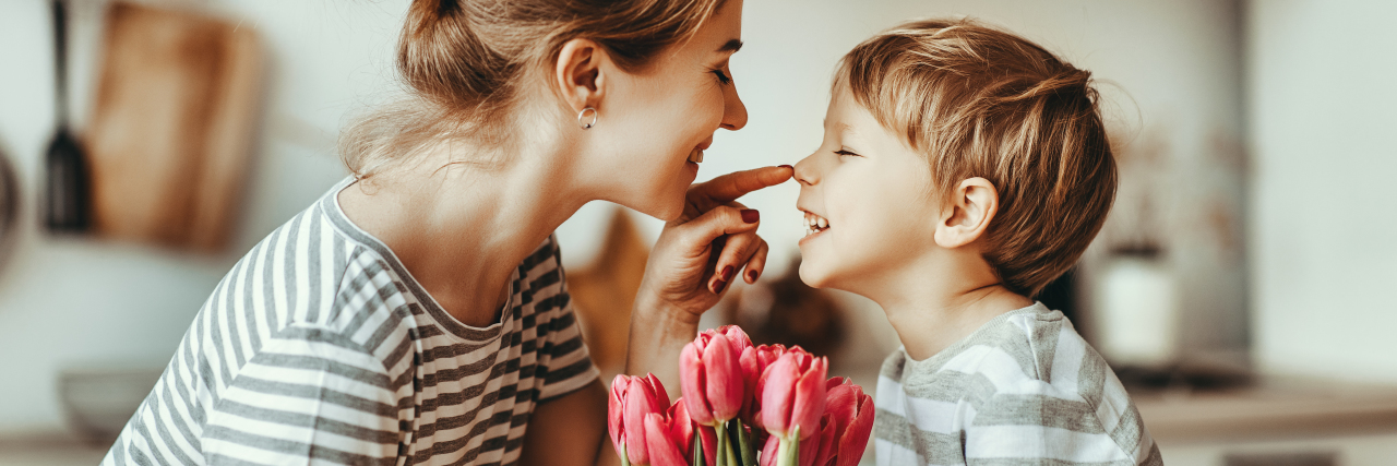 Son giving his mother flowers.