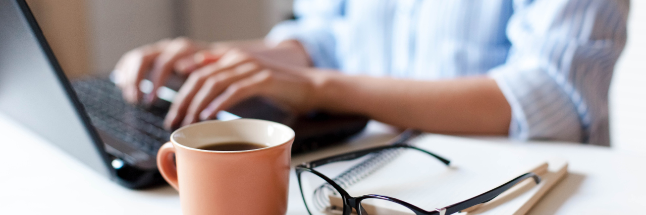 Why You Probably Have Autistic Coworkers -- but May Not Know It Person using laptop computer with cup of coffee nearby.