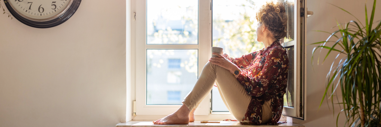 Young woman looking out of window.