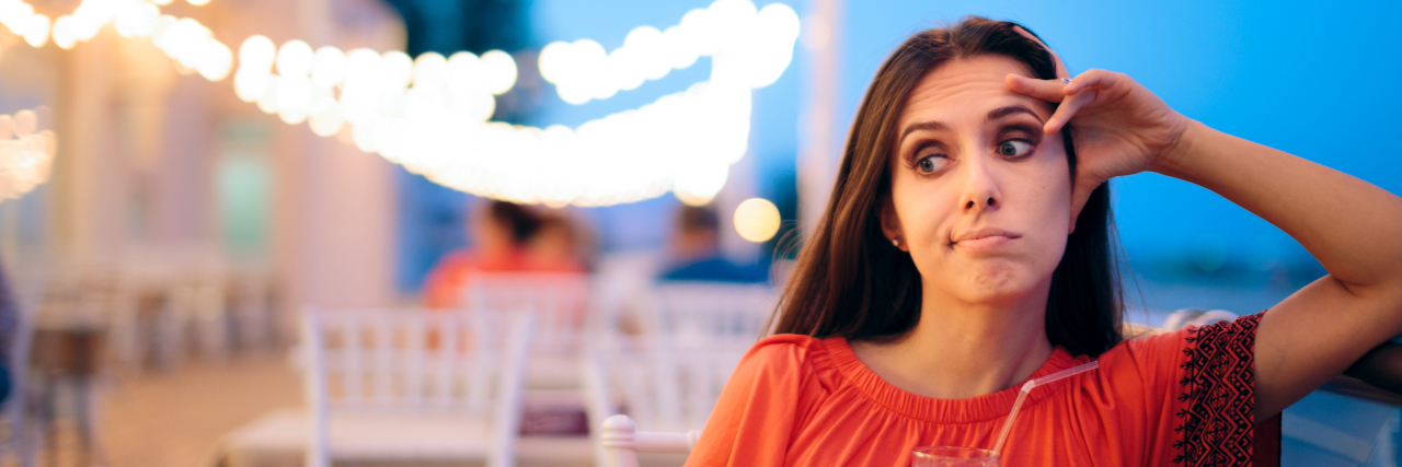 19 Things You've Thought While Dating With a Chronic Illness Woman looking awkward while waiting for date to arrive.