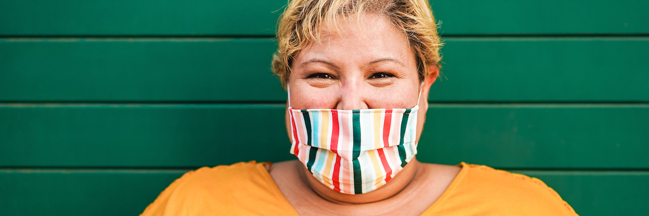 Why Fat People Shouldn't Feel Guilty About COVID Vaccine Priority A fat woman wearing a brightly colored mask