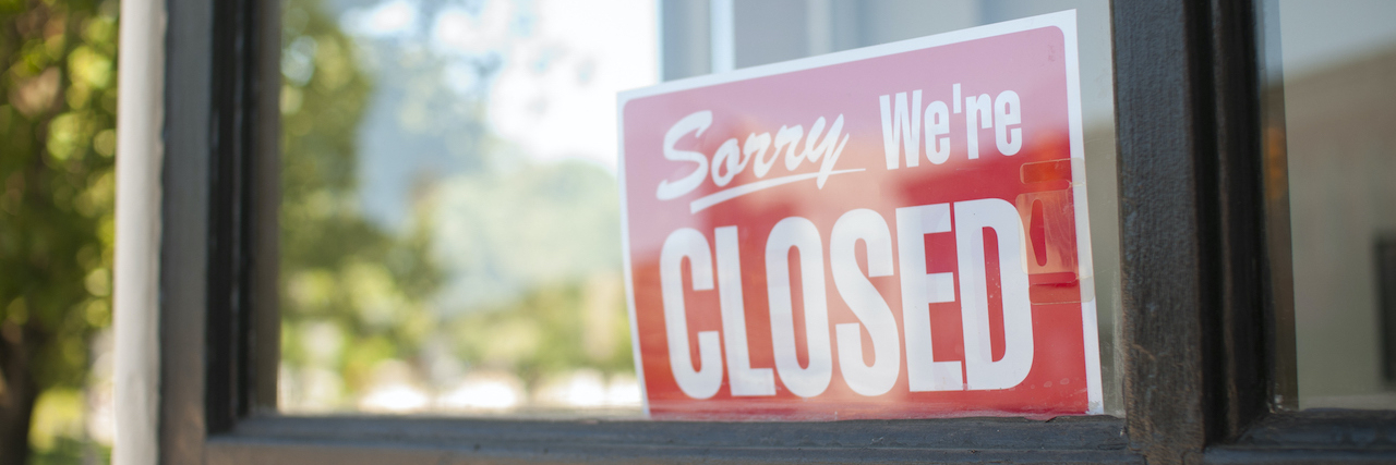 Sorry, We're Closed Sign in storefront window.