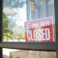 Sorry, We're Closed Sign in storefront window.