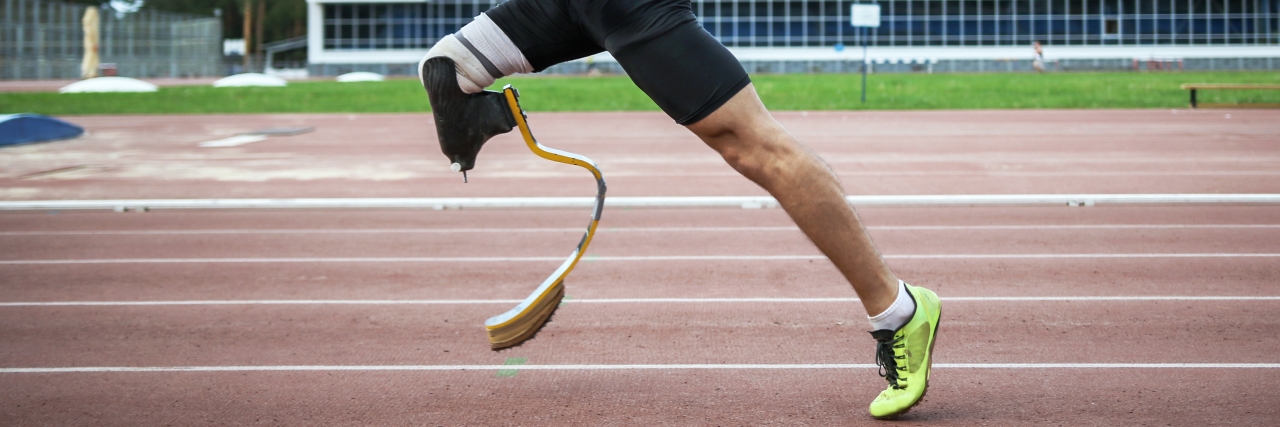 Athlete with prosthetic leg running.