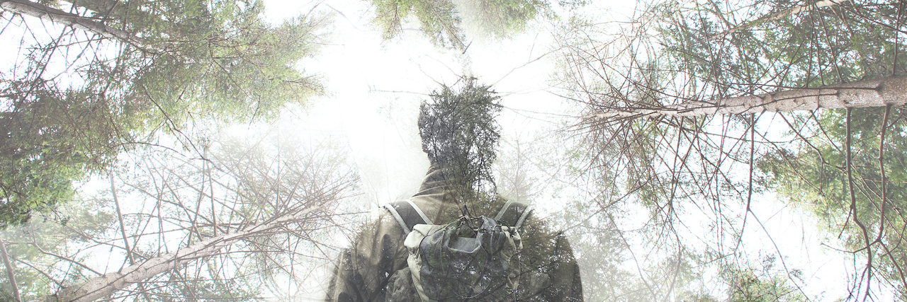 Double exposure of hiker walking in a mystic forest