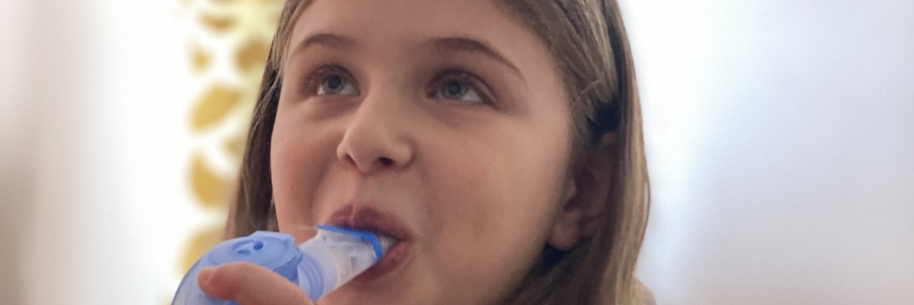 The Struggle to Help My Daughter With an Undiagnosed Rare Condition Jessica's daughter doing her breathing treatment.