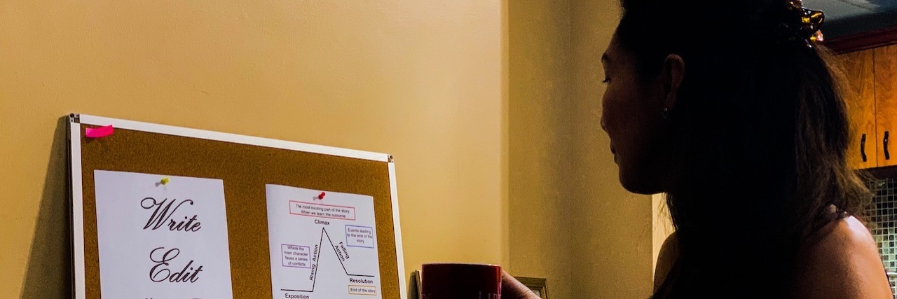 Writing Helped Me Overcome Stress and Frustration With Chronic Illness Image of the contributor sitting in front of a laptop and holding a mug