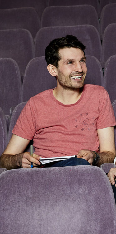 Photo of interviewee Toby Peach sitting alone in a theater audience