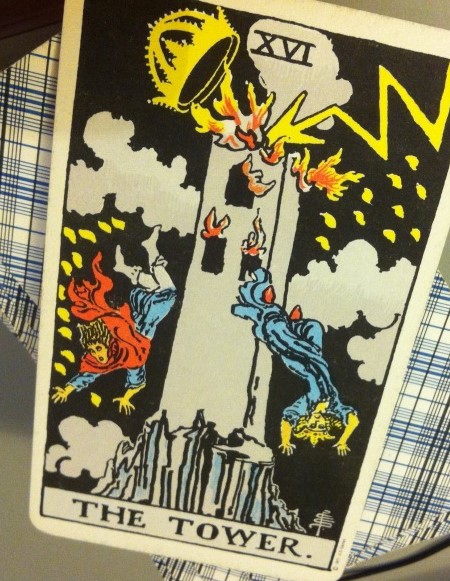 Image of the tarot "Tower" card, which shows figures jumping out of a burning tower 