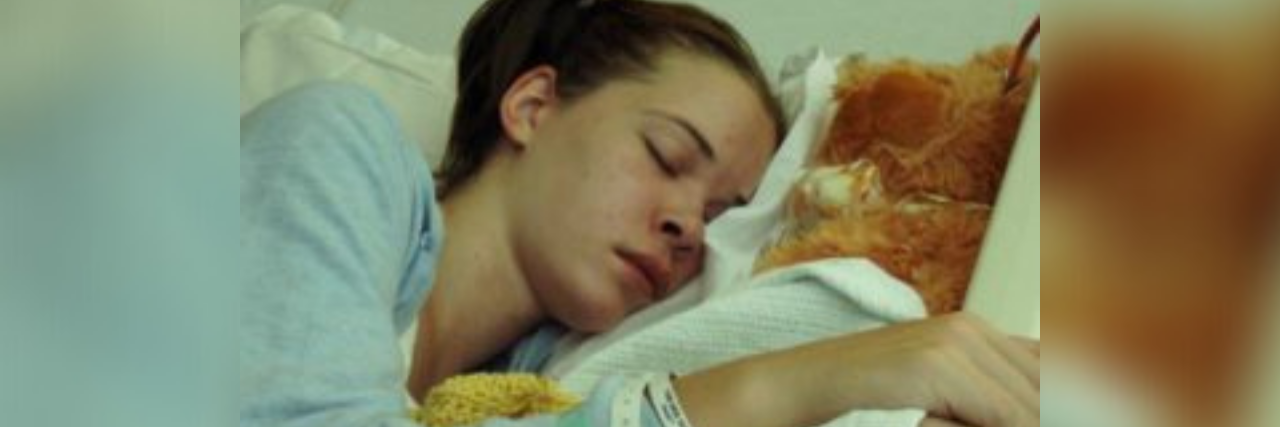 My Chronic Illness Treatment Ended Badly, but Was Right at the Time Photo of author, a young white woman with brown hair, lying in a hospital bed after surgery asleep