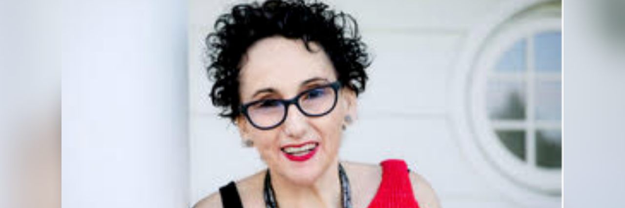 The Key to My Recovery From Borderline Personality Disorder  photo of author; white woman smiling, short curly black hair wearing a red sweater