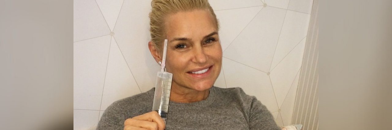 Yolanda Hadid's Missed Chronic Illness Warning Signs Yolanda Hadid lying in a hospital bed, smiling