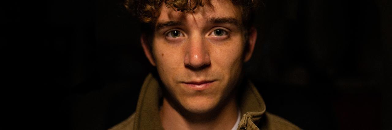 Responding To Schizophrenia and Psychosis With Kindness and Patience photo of a man looking into camera with teary eyes, against black backdrop