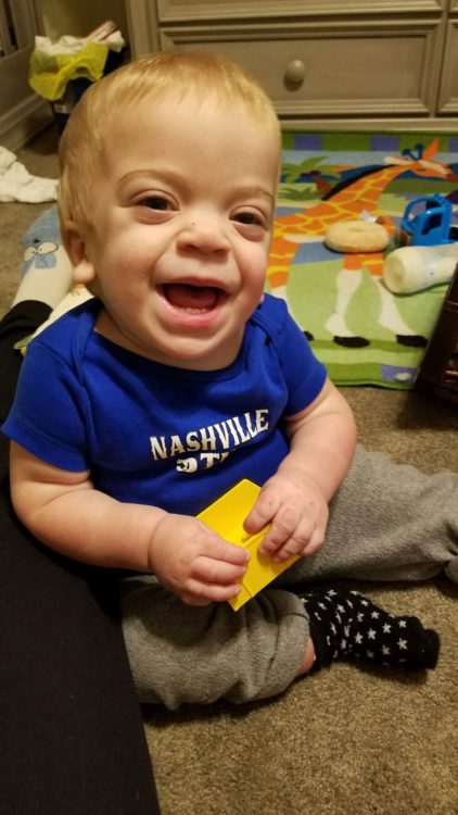 Photo of a smiling boy holding a toy